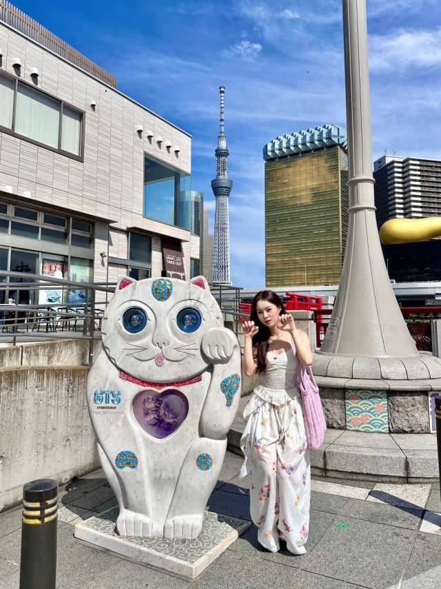 From Asakusa station, find the charming cat statue for the perfect photo opportunity with the Tokyo Skytree.
