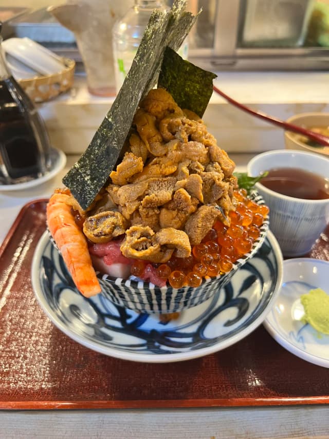 A mountain of minced tuna, fish slices, sea urchin, and shrimp—wrapping it all in seaweed with rice for one bite is unbelievably satisfying!